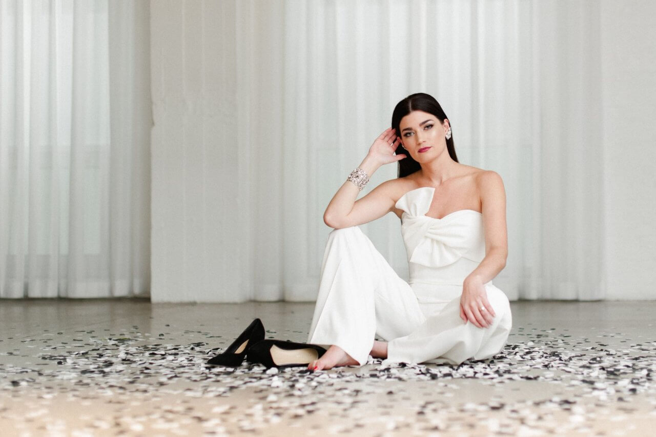 bride sitting in black and white confetti in white space