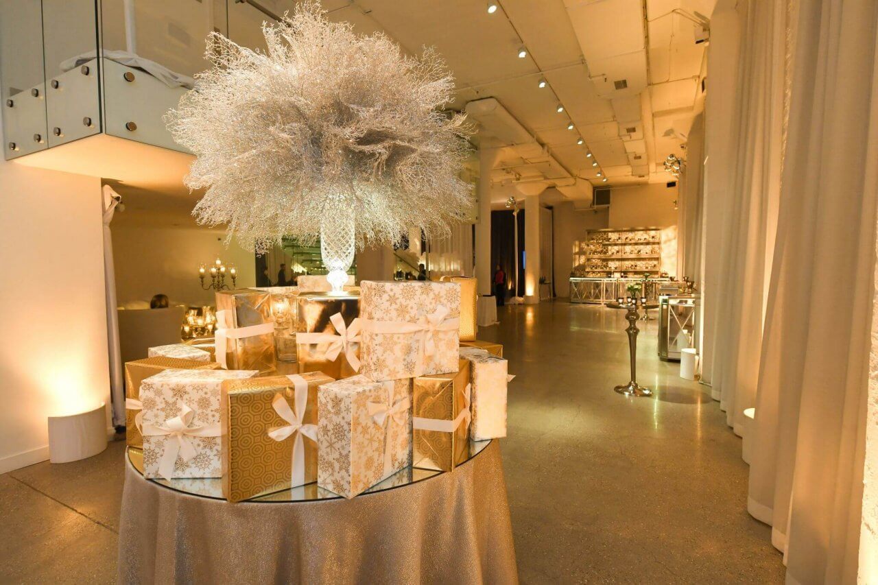 gold holiday gift table with feather centerpiece and gifts